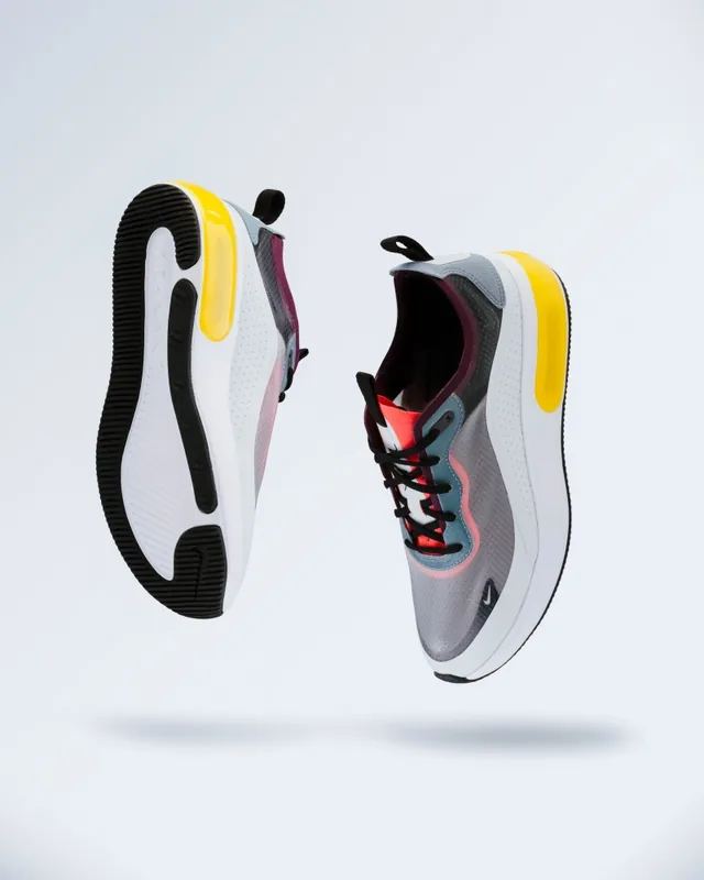 Two sneakers floating over a light grey backdrop with soft shadows